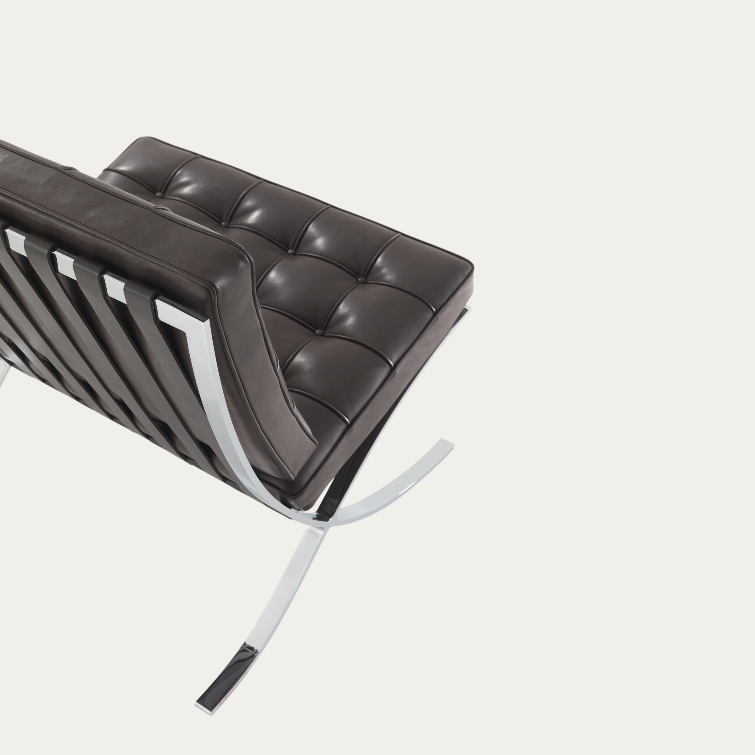 Rückansicht des dunkelbraunen Barcelona Chairs von Mies van der Rohe mit poliertem Kreuzgestell und Lederpolsterung