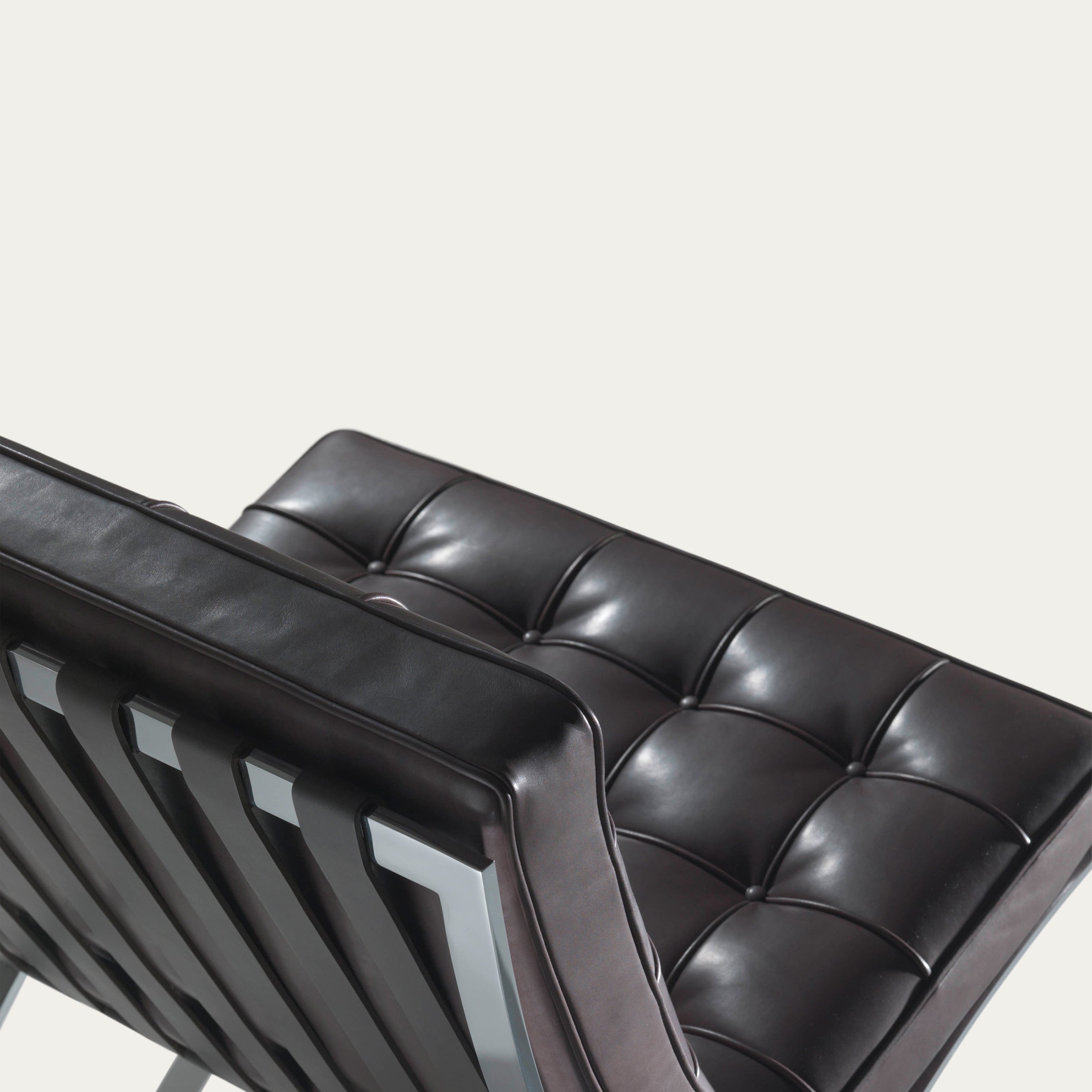 Detailaufnahme der Rückseite des Barcelona Chairs von Mies van der Rohe in schokoladenbraunem Leder mit poliertem Stahlrahmen