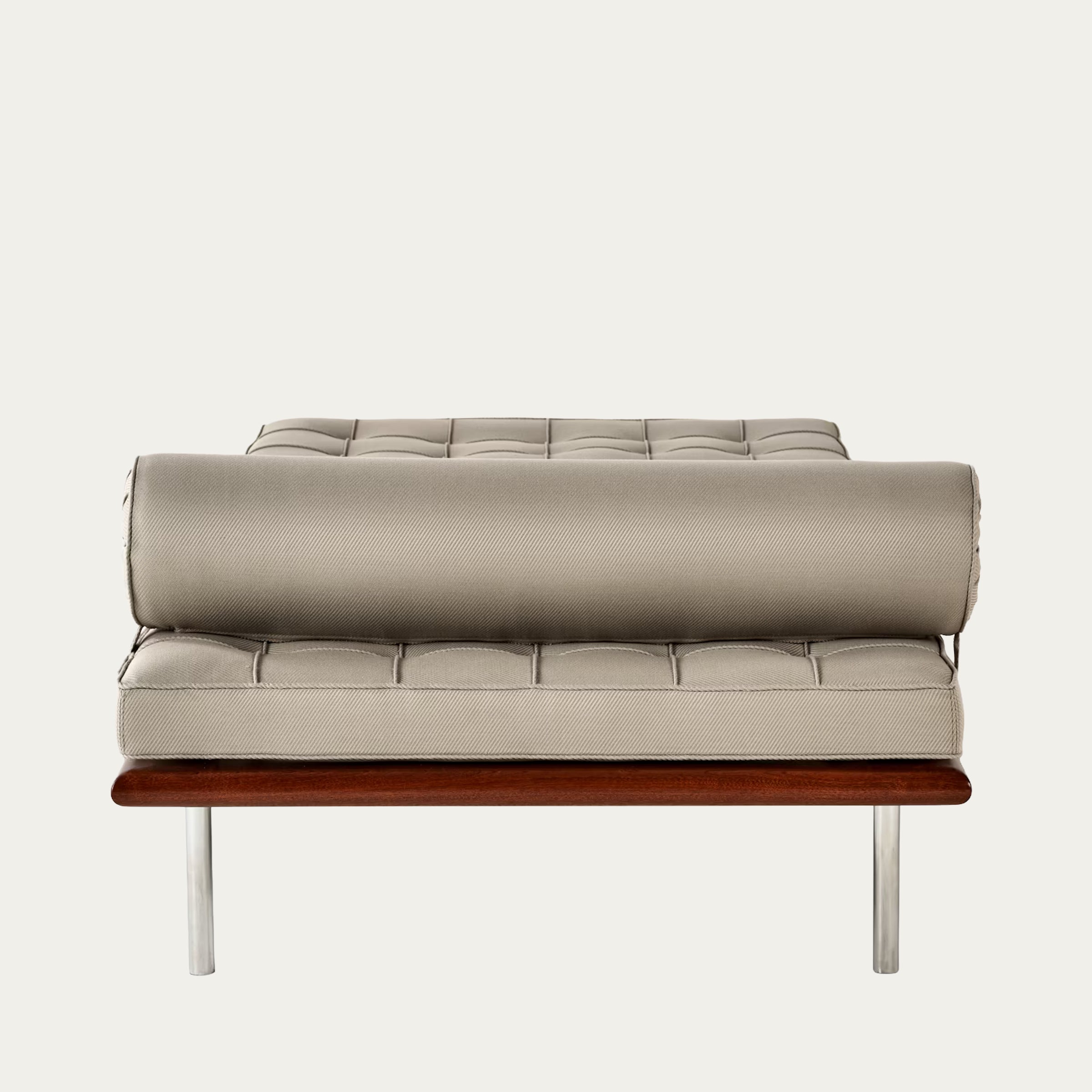 Seitliche Nahaufnahme der Barcelona Couch von Ludwig Mies van der Rohe (1930) in hellem Beige mit charakteristischer Kapitonierung und Nackenrolle