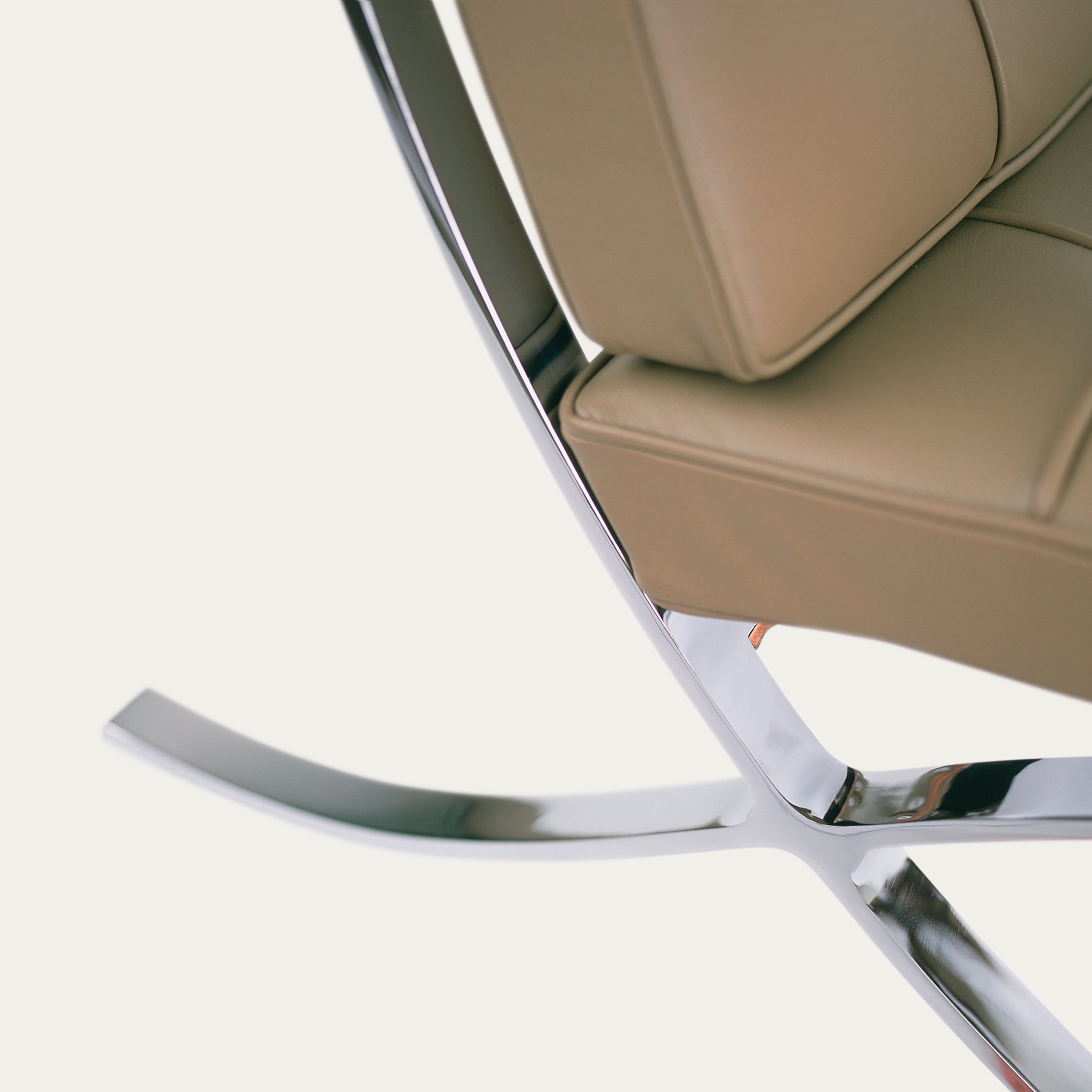 Nahaufnahme des Barcelona Chairs mit Fokus auf das verchromte X-Gestell und das braune Lederpolster