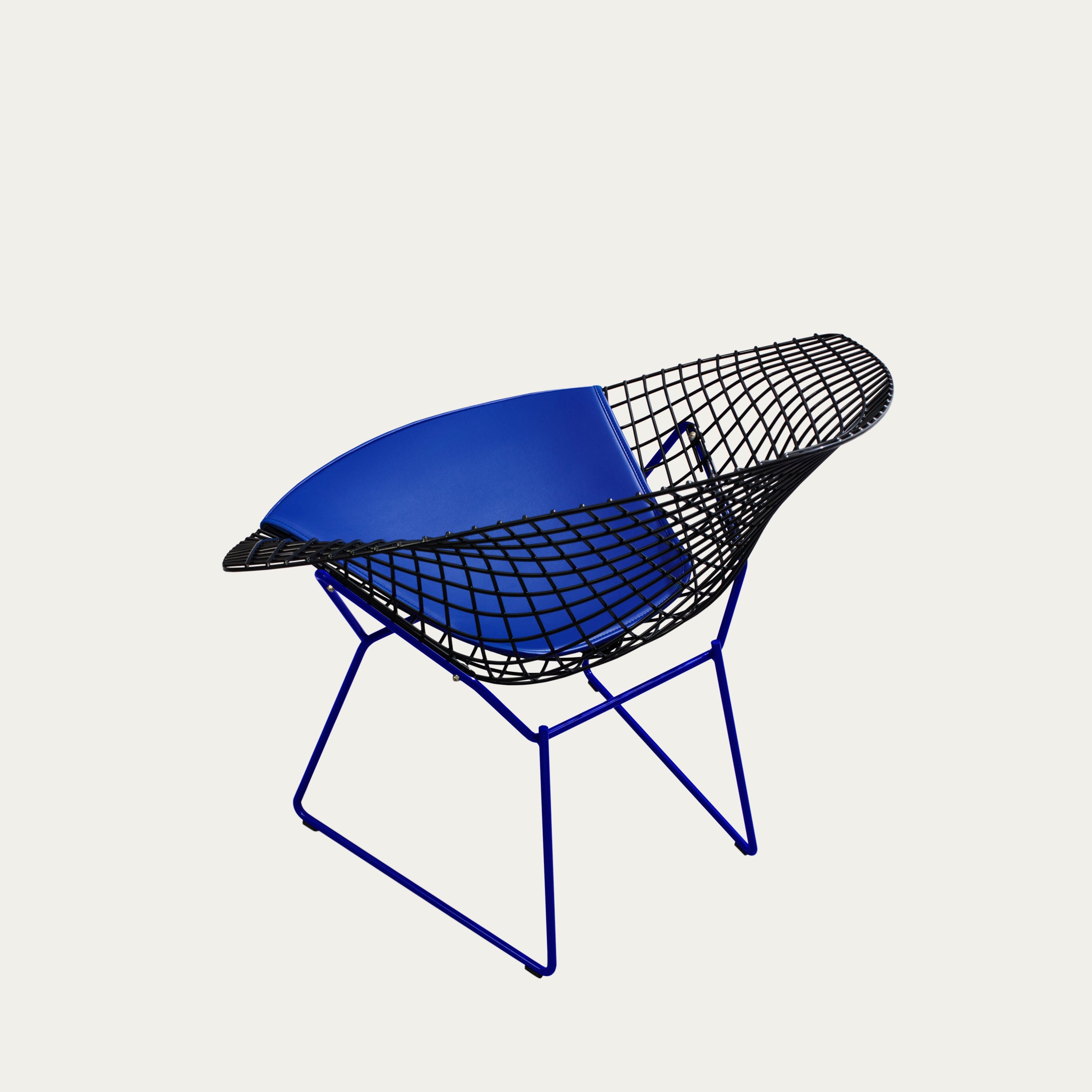 Schrägansicht des Diamond Chairs mit schwarzem Drahtgestell, blauer Sitzschale und blauem Untergestell