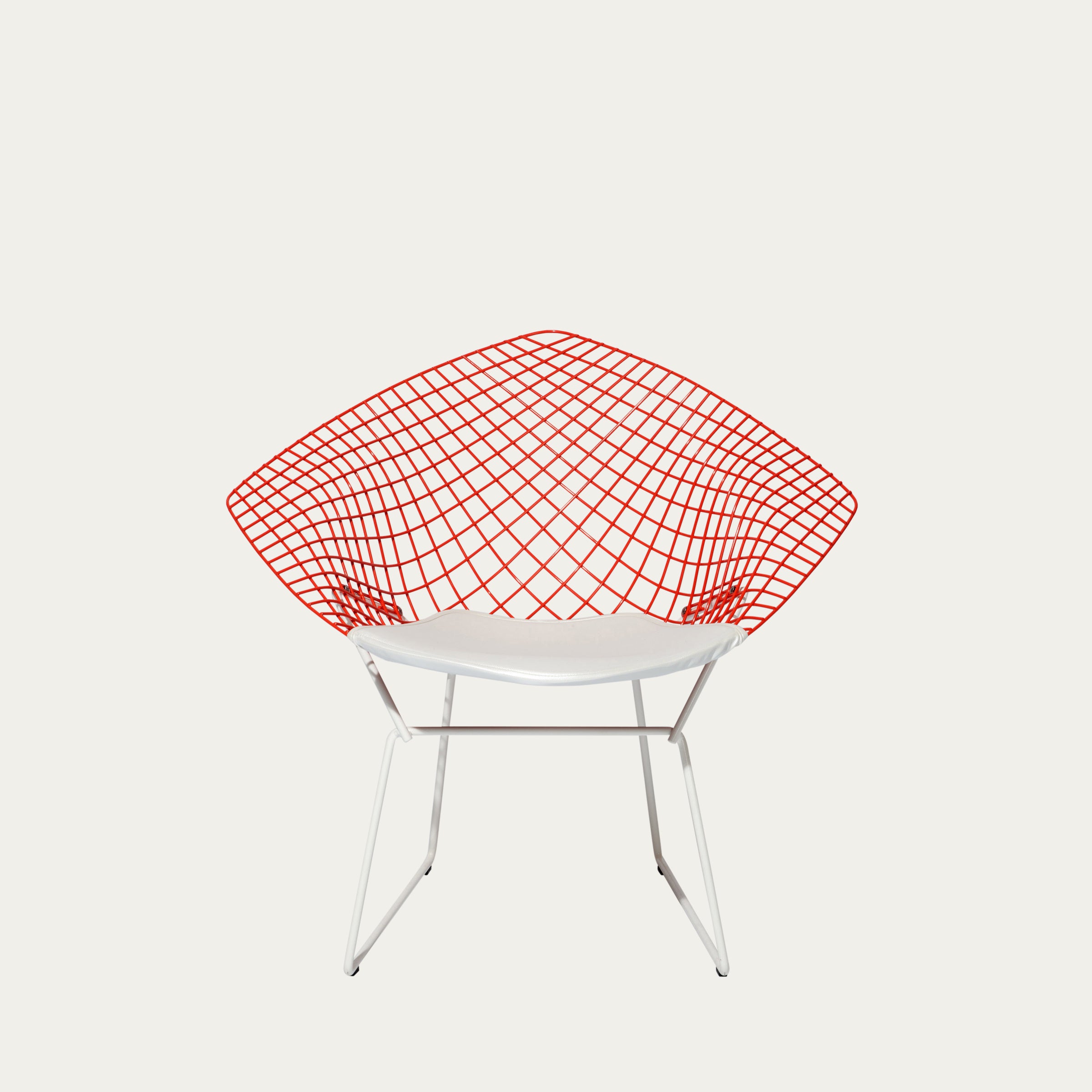 Frontalansicht des Diamond Chairs mit signalrotem Drahtgitterrahmen und elegantem weißen Polster