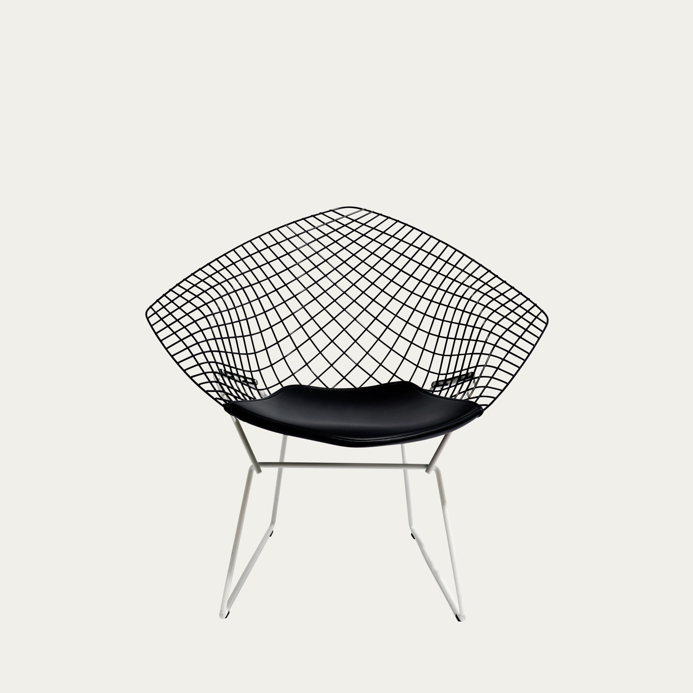 Frontalansicht des Diamond Chairs mit schwarzem Sitzpolster und weiß lackiertem Drahtgestell
