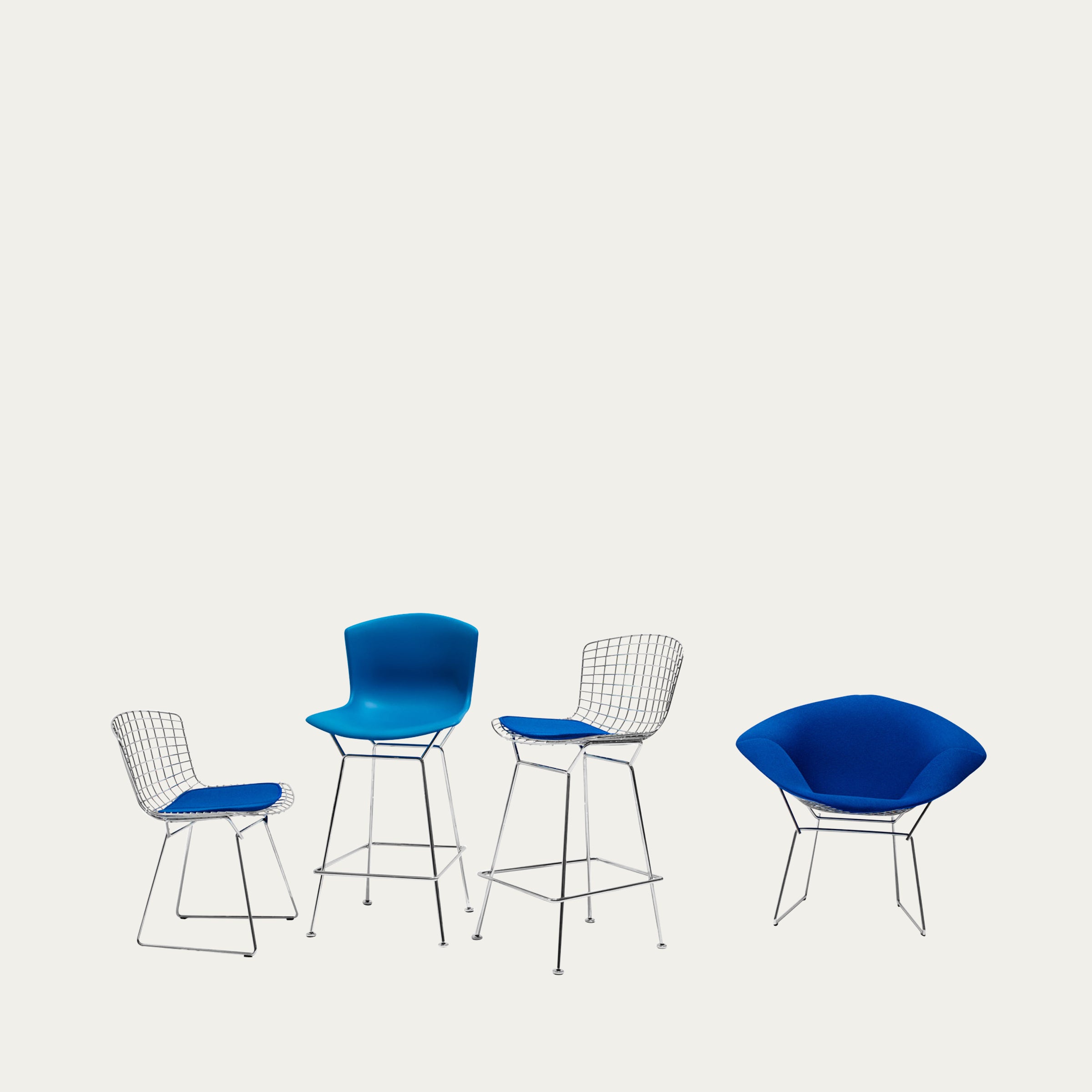 Mehrere Barhocker und Sessel von Harry Bertoia in blauer Polsterung und Drahtkonstruktion nebeneinander präsentiert