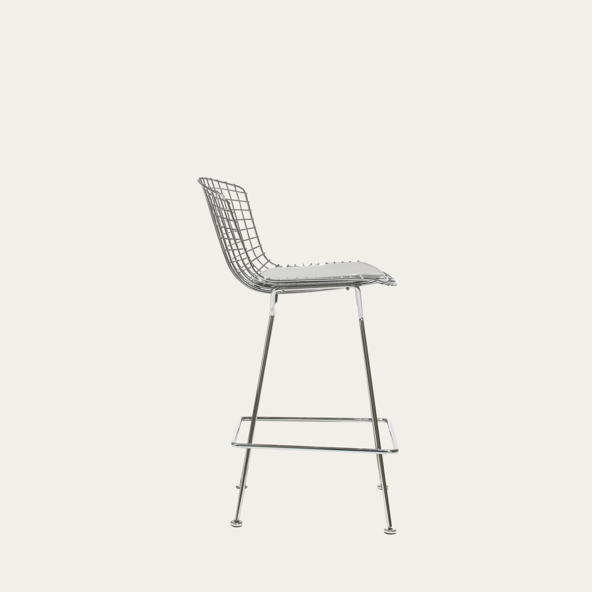 Seitenansicht eines weißen Harry-Bertoia-Barhockers mit offenem Drahtgestell und Sitzkissen