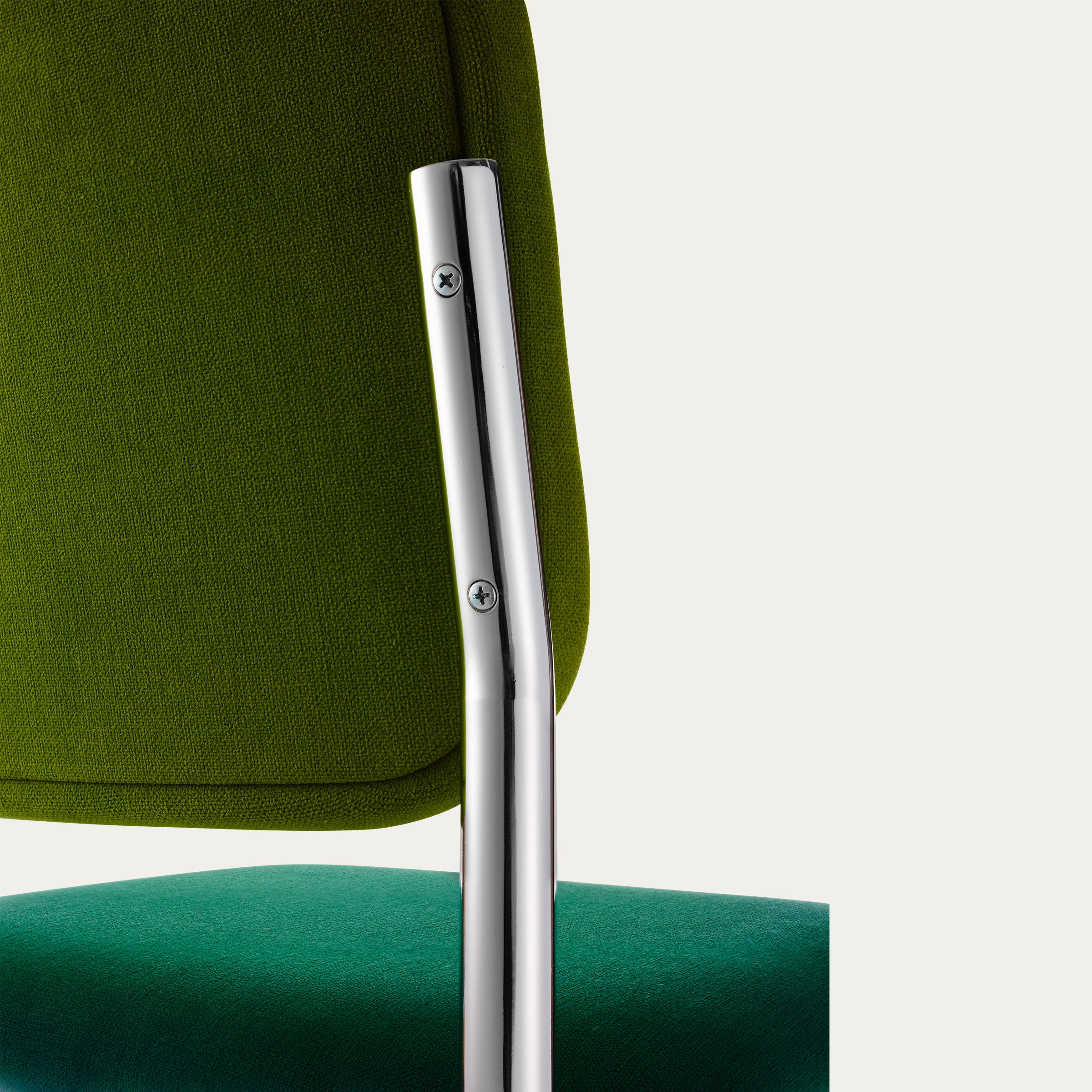 Detailaufnahme der grünen Rückenlehne des Cesca Stuhls von Marcel Breuer mit glänzendem Stahlrohrgestell