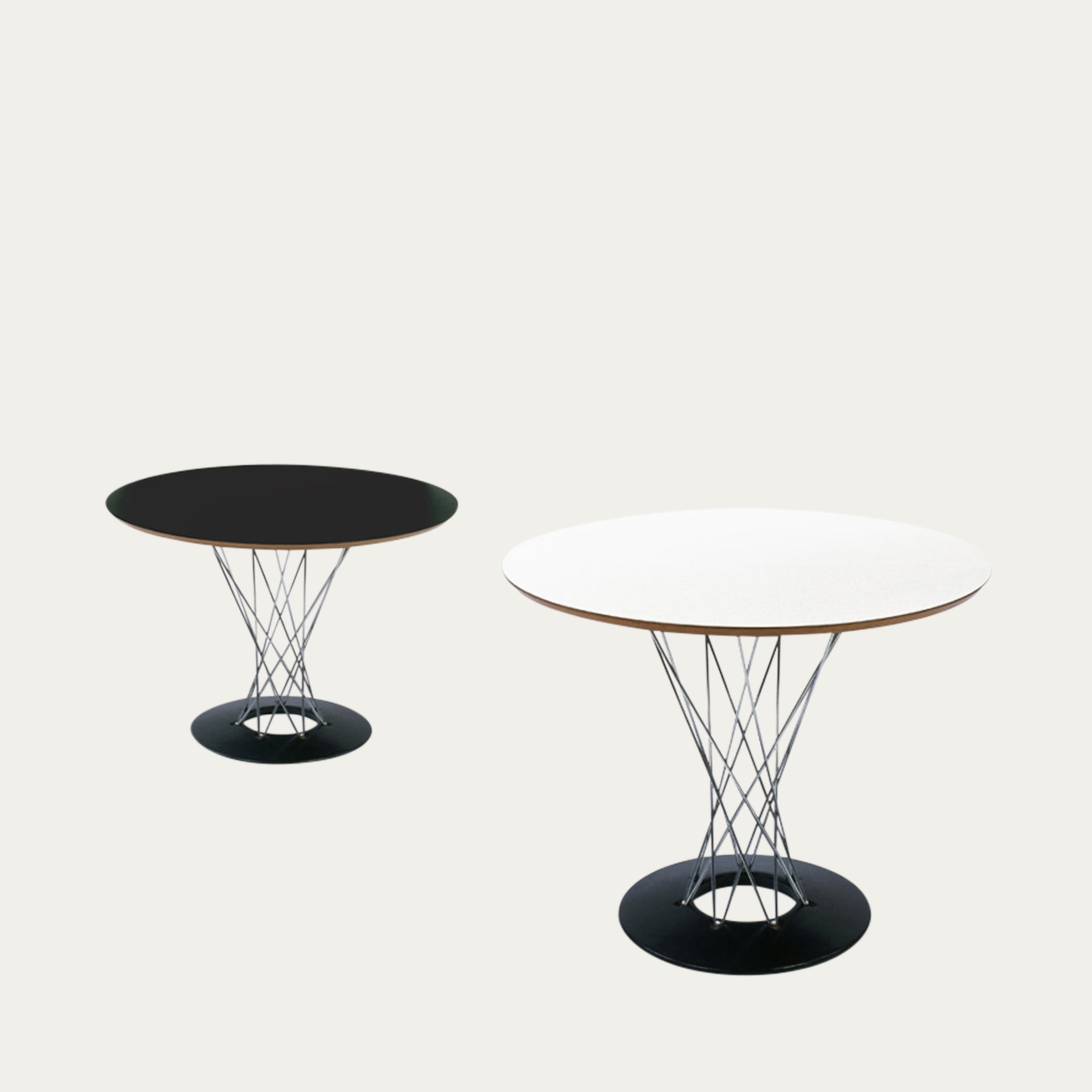 Zwei Varianten des Cyclone Tisches von Isamu Noguchi, eine mit schwarzer Platte und eine mit weißer Platte, beide mit dem charakteristischen verdrehten Drahtgestell