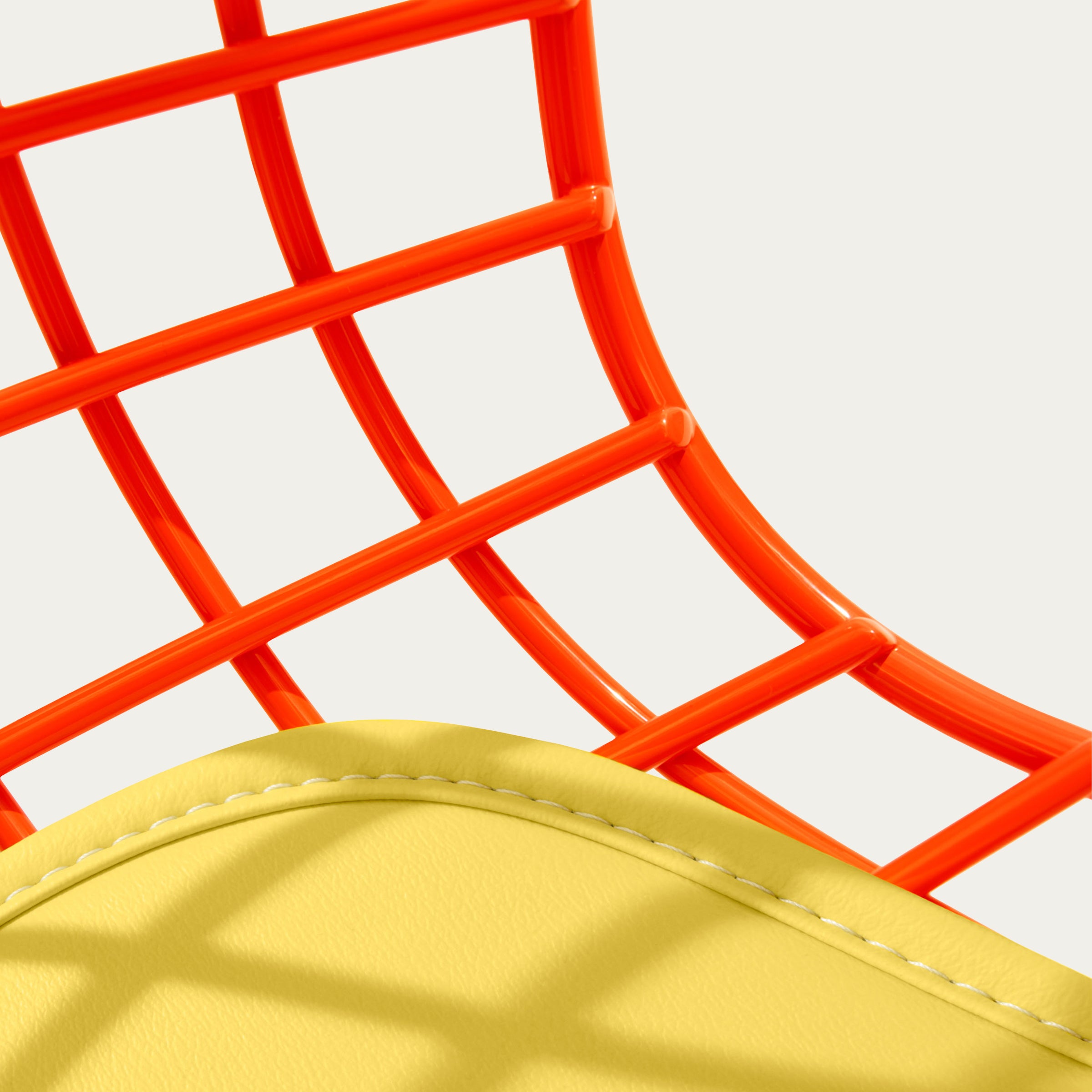 Nahaufnahme des Bertoia Side Chairs mit orangefarbenem Drahtgeflecht und gelbem Sitzpolster