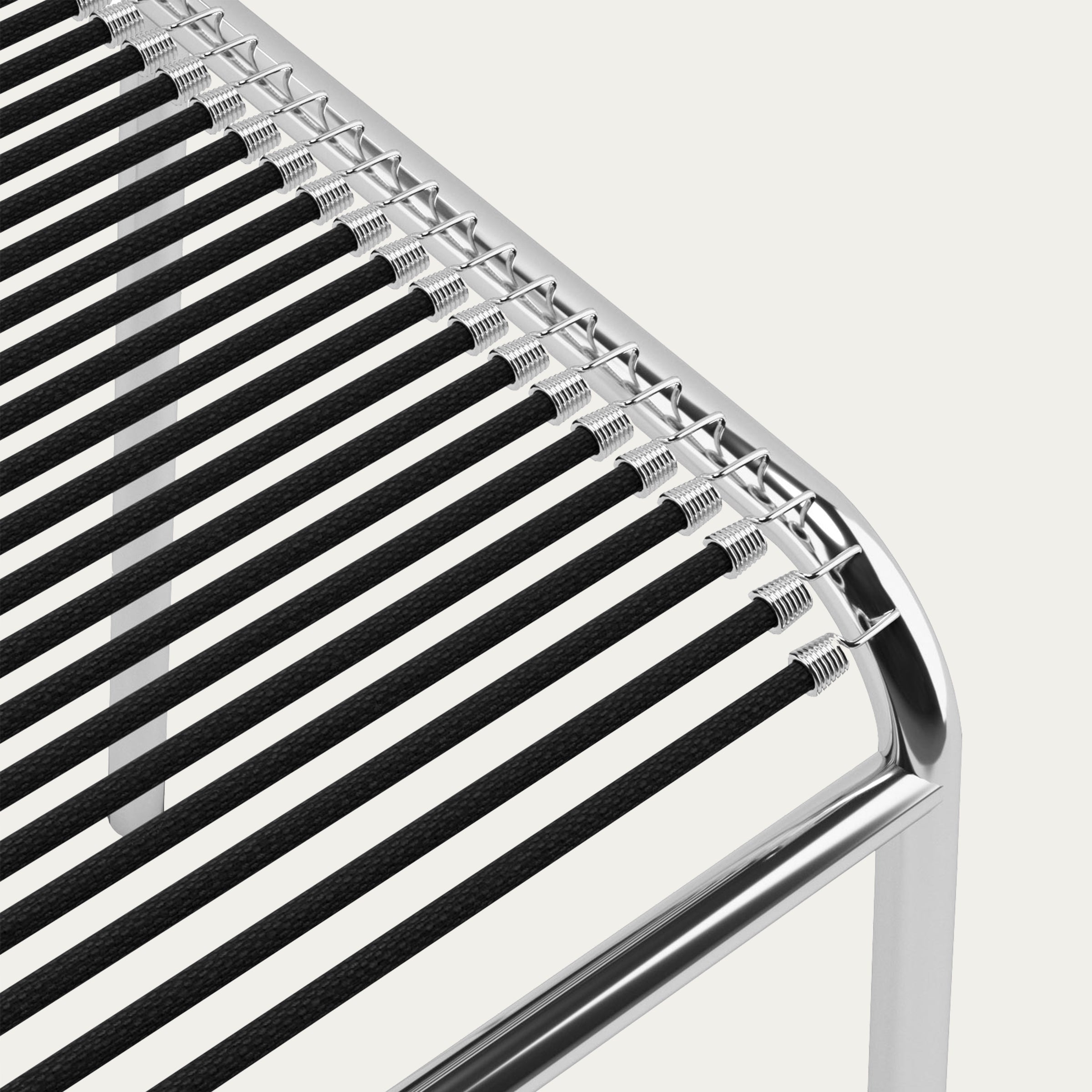 Nahaufnahme der Sitzfläche des Sandows Stuhls von René Herbst mit eng gespannten schwarzen Gummibändern auf einem verchromten Gestell