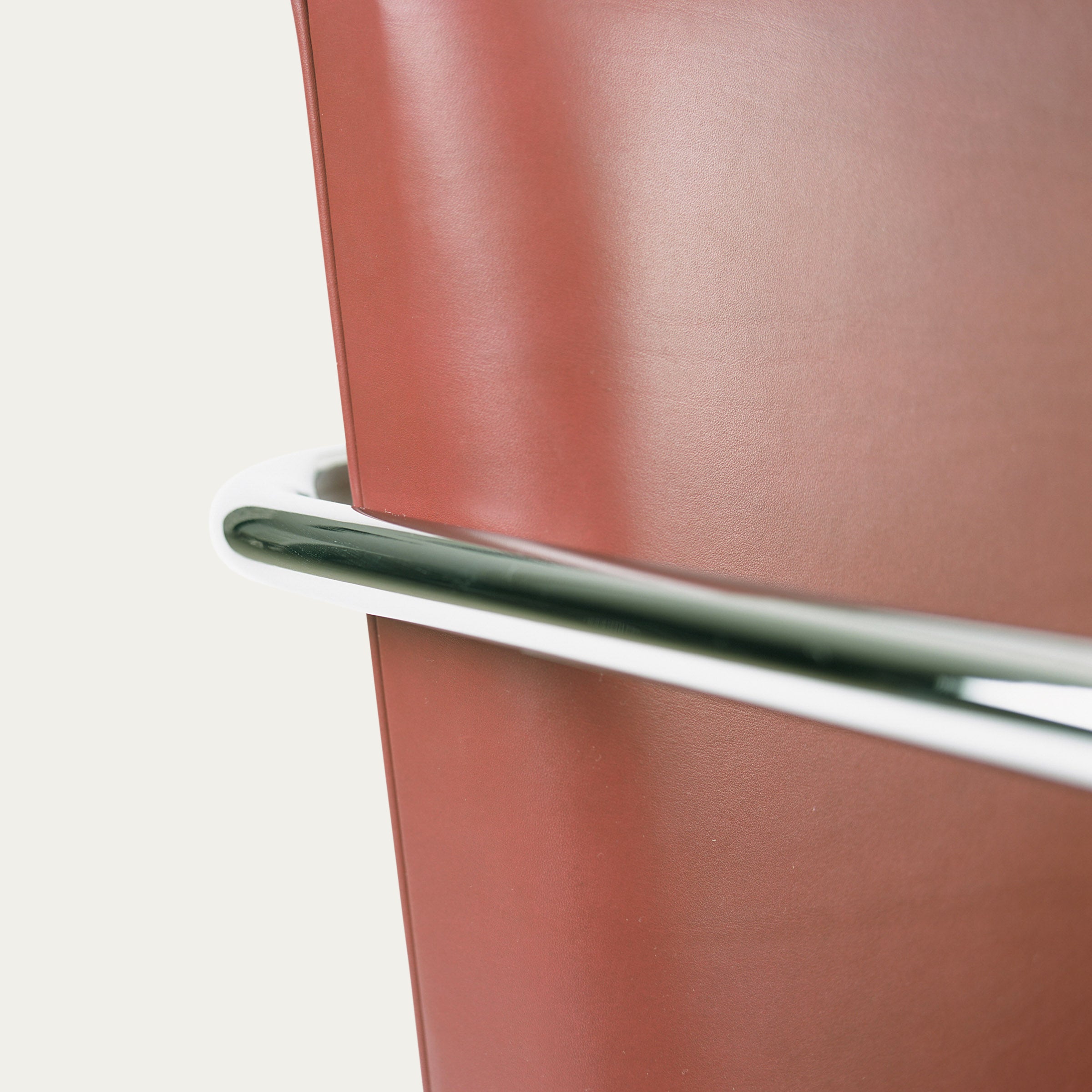 Nahaufnahme der rotbraunen Rückenlehne und des polierten Stahlrohrs des Tubular Brno Freischwingers, entworfen 1930 von Mies van der Rohe