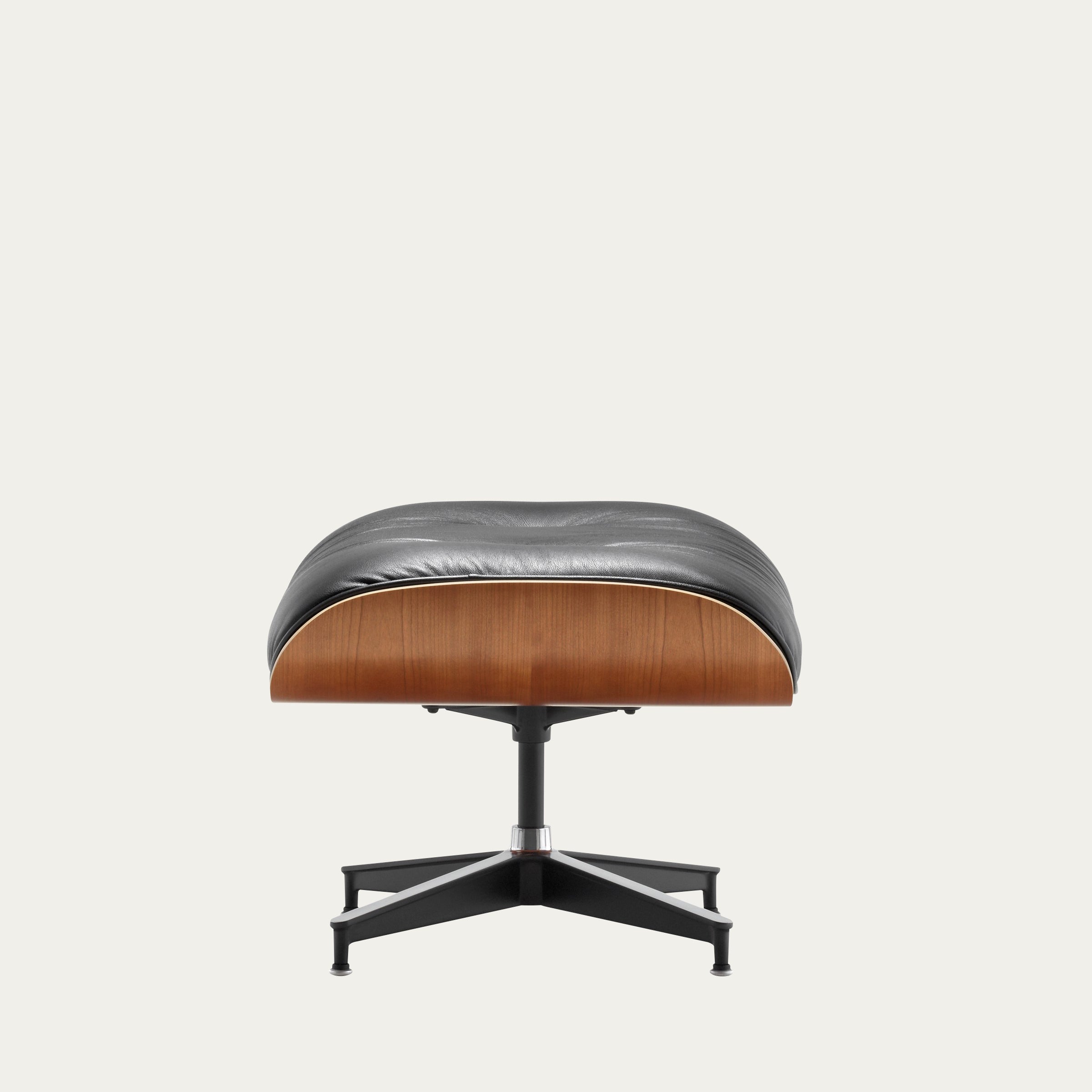 Seitenansicht des Eames Ottoman von Charles & Ray Eames mit schwarzer Lederpolsterung und Nussbaum-Schichtholz