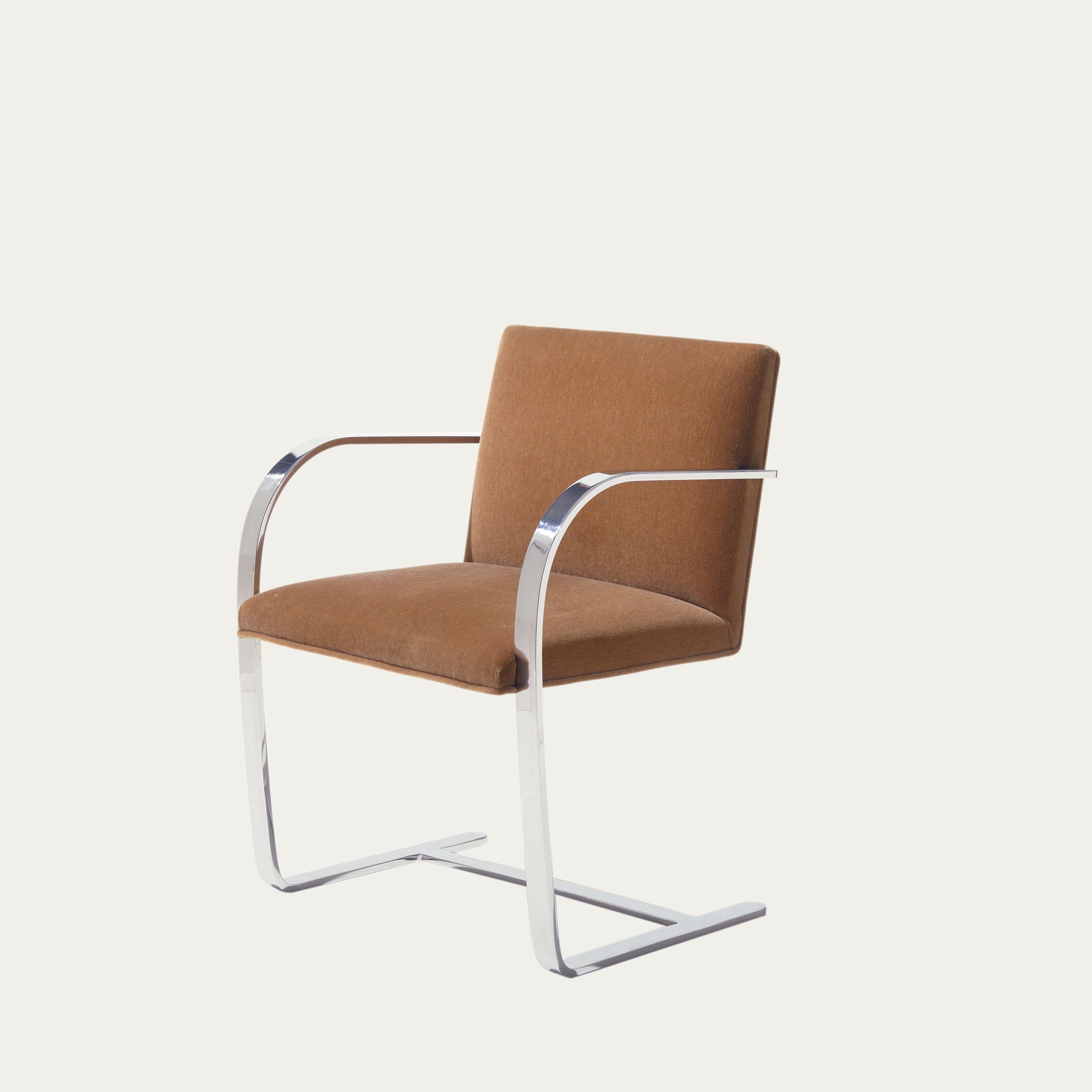 Schrägansicht des Flat Bar Brno Freischwingers mit braunem Stoffpolster und verchromtem Flachstahlgestell