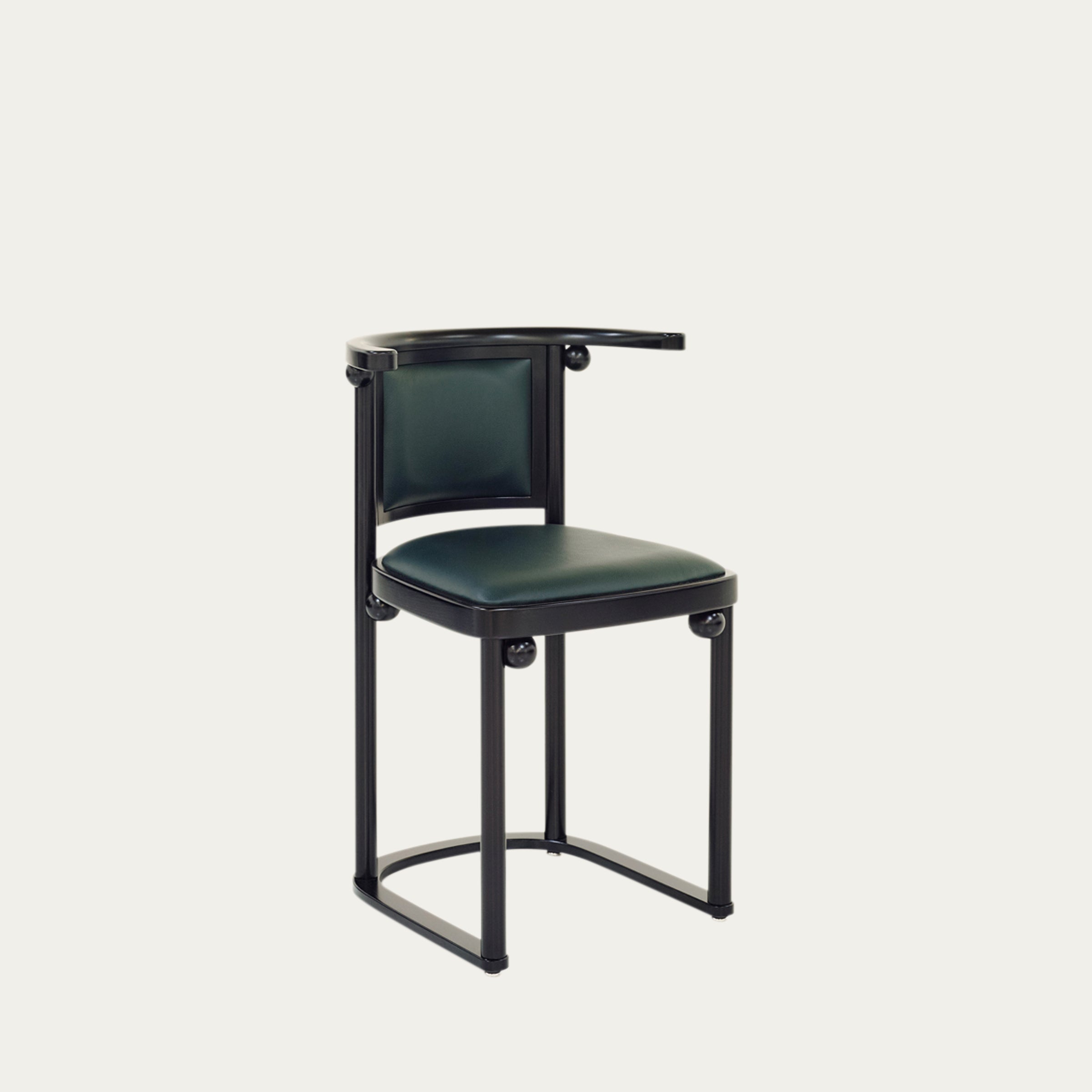 Schrägansicht des Fledermaus Stuhls von Josef Hoffmann mit dunkelgrünem Polster und schwarzem Holzrahmen