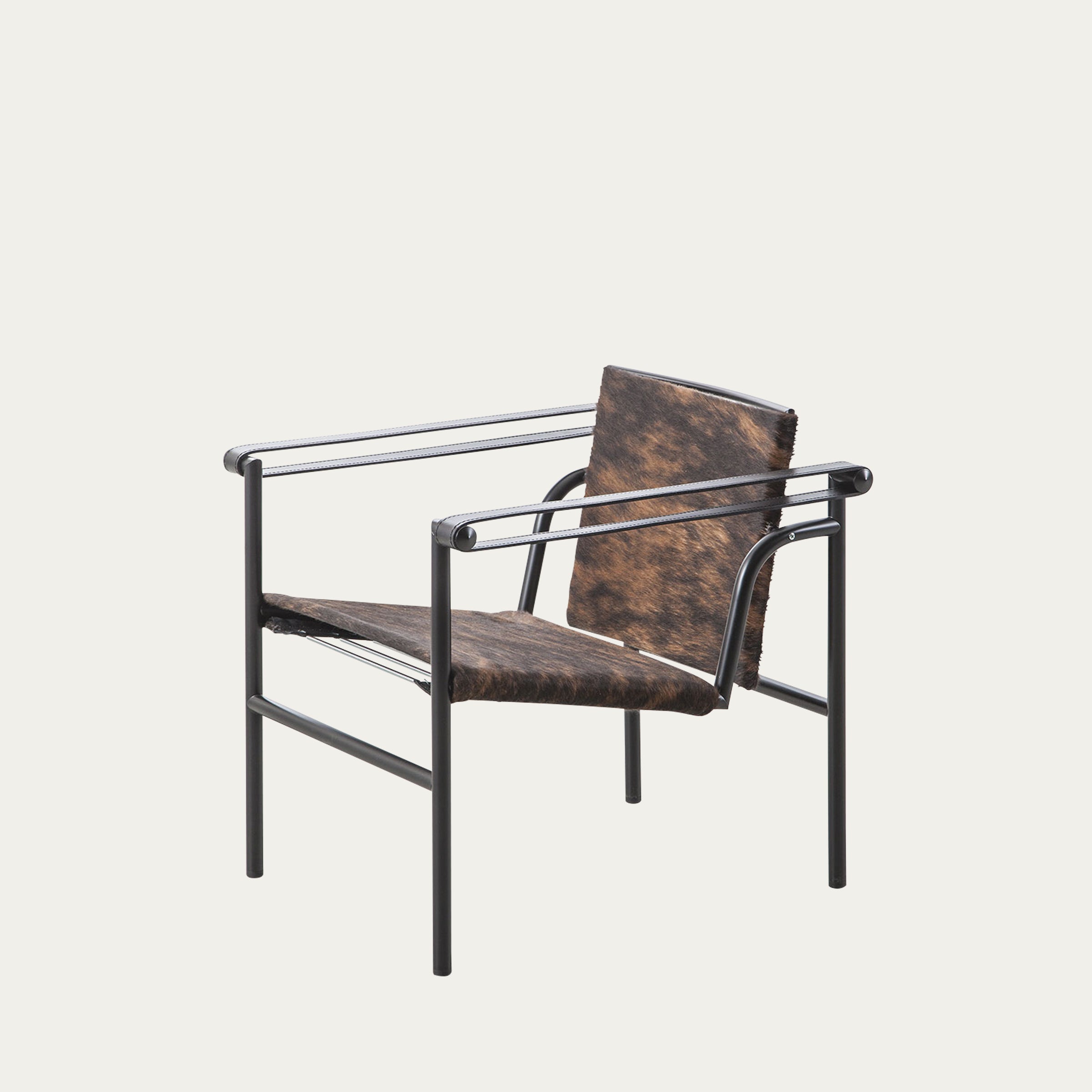 Schrägansicht des LC1 Sessels von Le Corbusier in Kuhfelloptik, kombiniert mit schwarzem pulverbeschichtetem Stahlrahmen