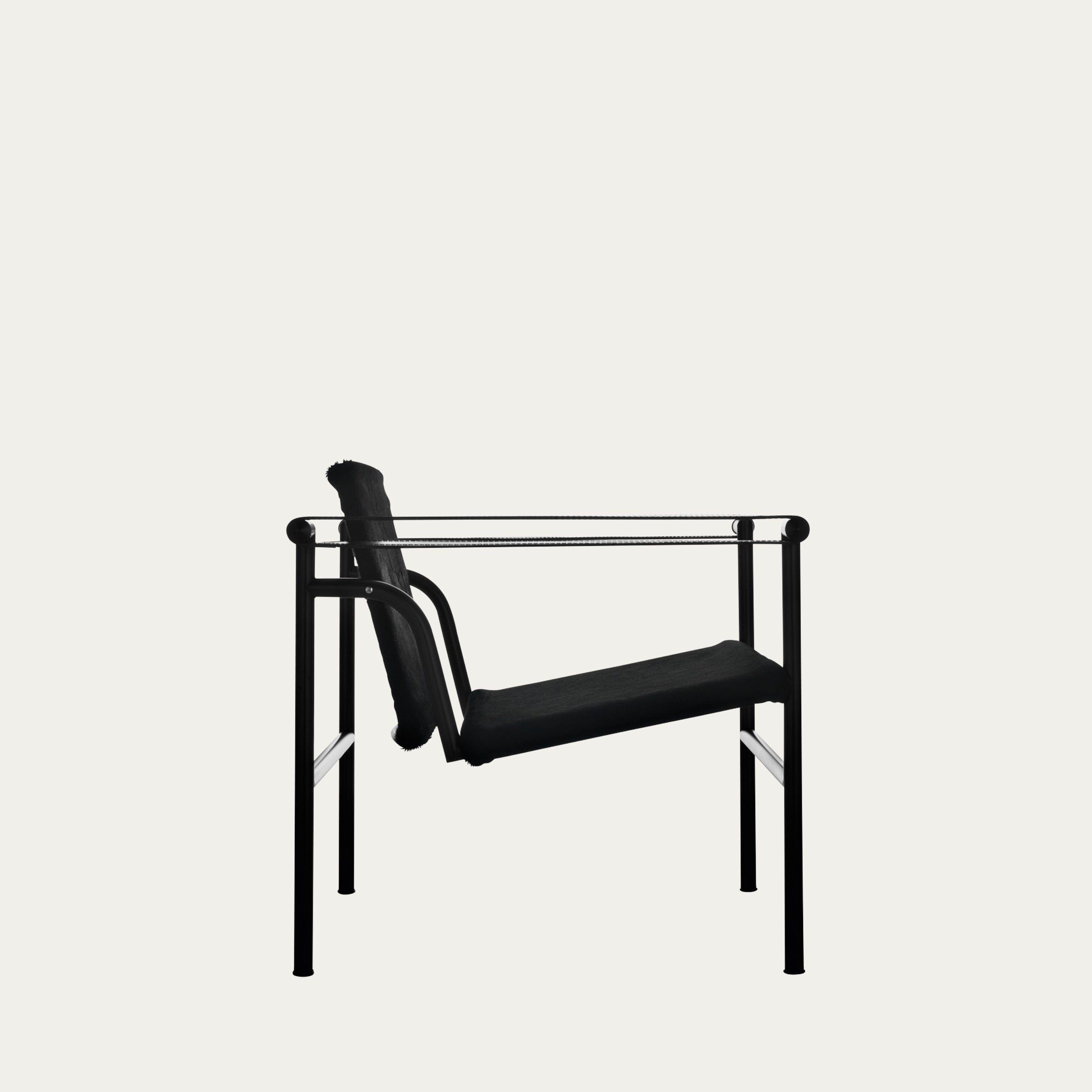 Seitliche Aufnahme des LC1 Sessels von Le Corbusier in Schwarz, mit schwarzem Leder und pulverbeschichtetem Stahlrahmen