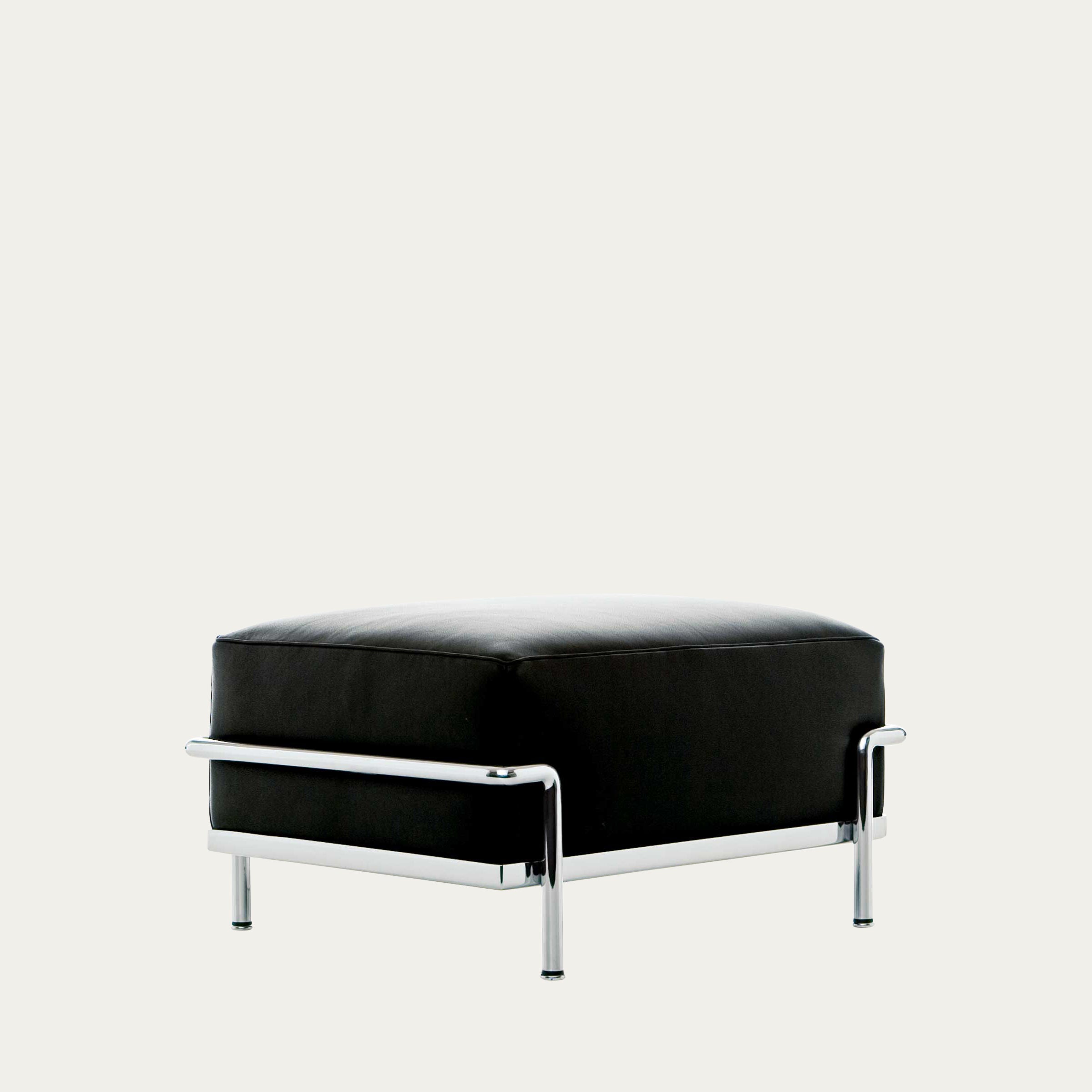 Seitliche Ansicht des LC2 Ottoman Petit Modèle – schwarzer Lederhocker mit verchromtem Stahlrohrgestell