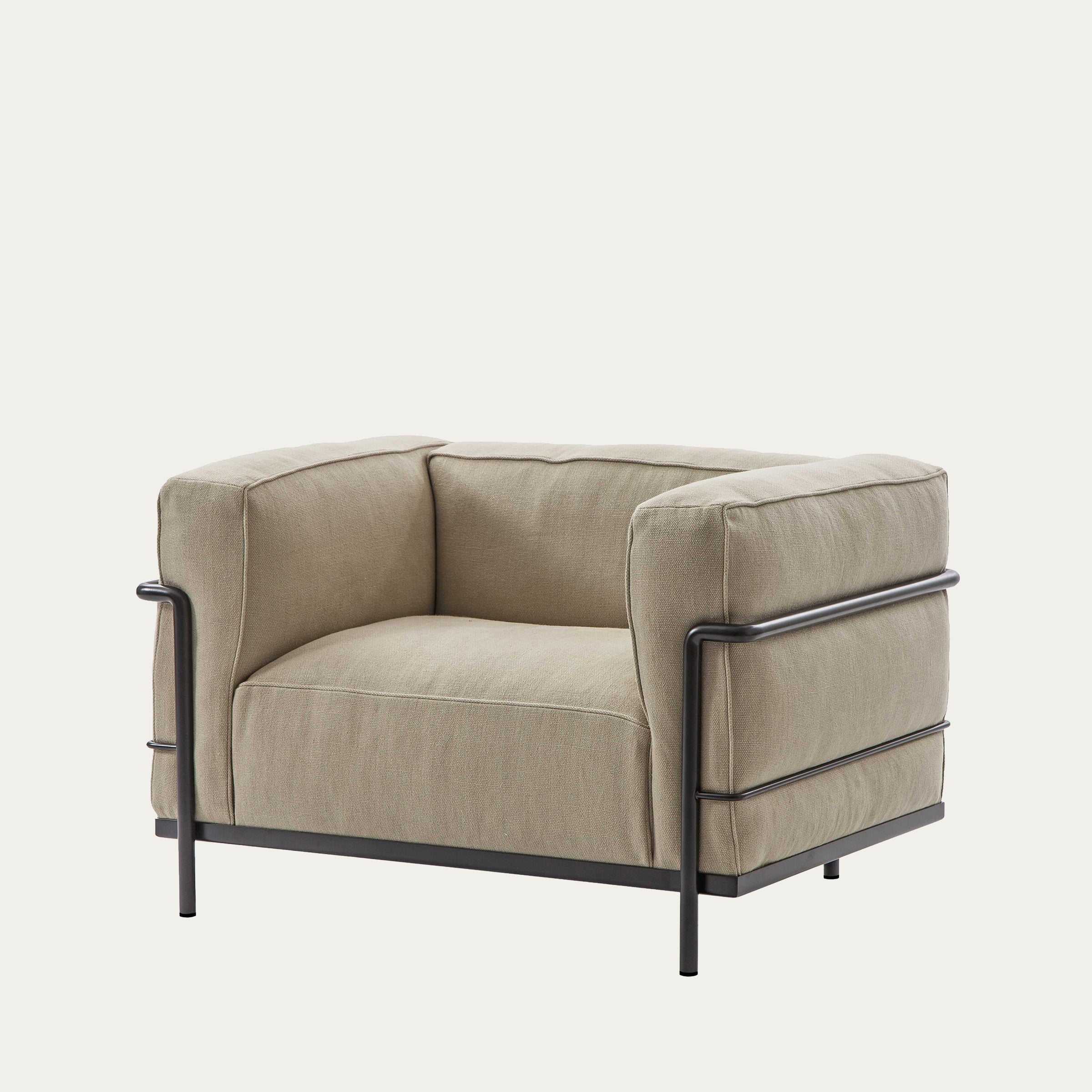 Seitliche Ansicht des LC3 Sessels Grand Modèle von Le Corbusier mit hellem Stoffbezug und dunklem Stahlrahmen