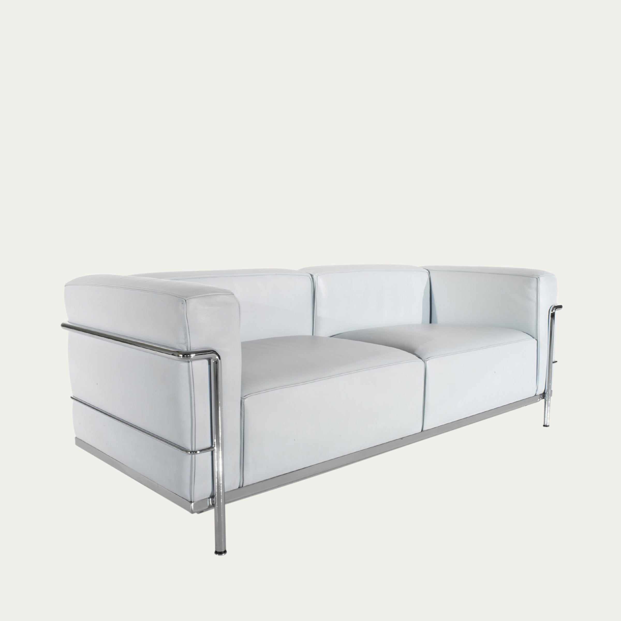 Schrägansicht des LC3 Sofas von Le Corbusier als Zweisitzer in weißem Leder mit verchromtem Stahlrohrrahmen