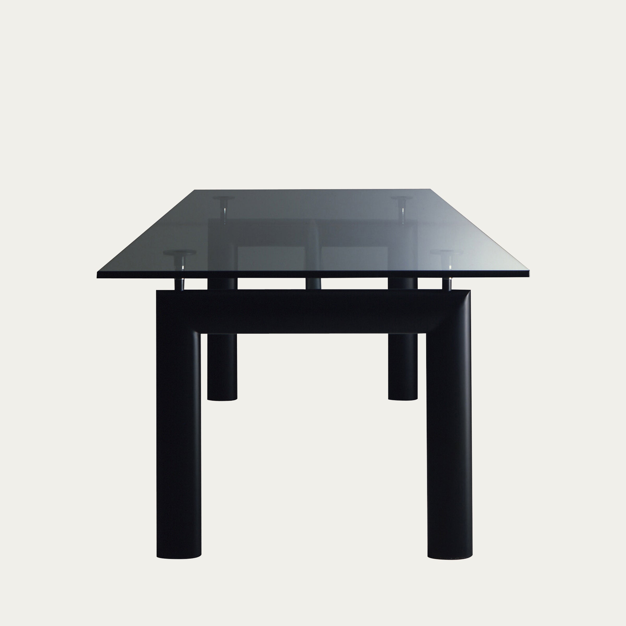 Frontalperspektive des LC6 Table Tube d’Avion von Le Corbusier – klare Glasplatte auf schwarzem, röhrenförmigem Stahlunterbau, Bauhausklassiker von 1929