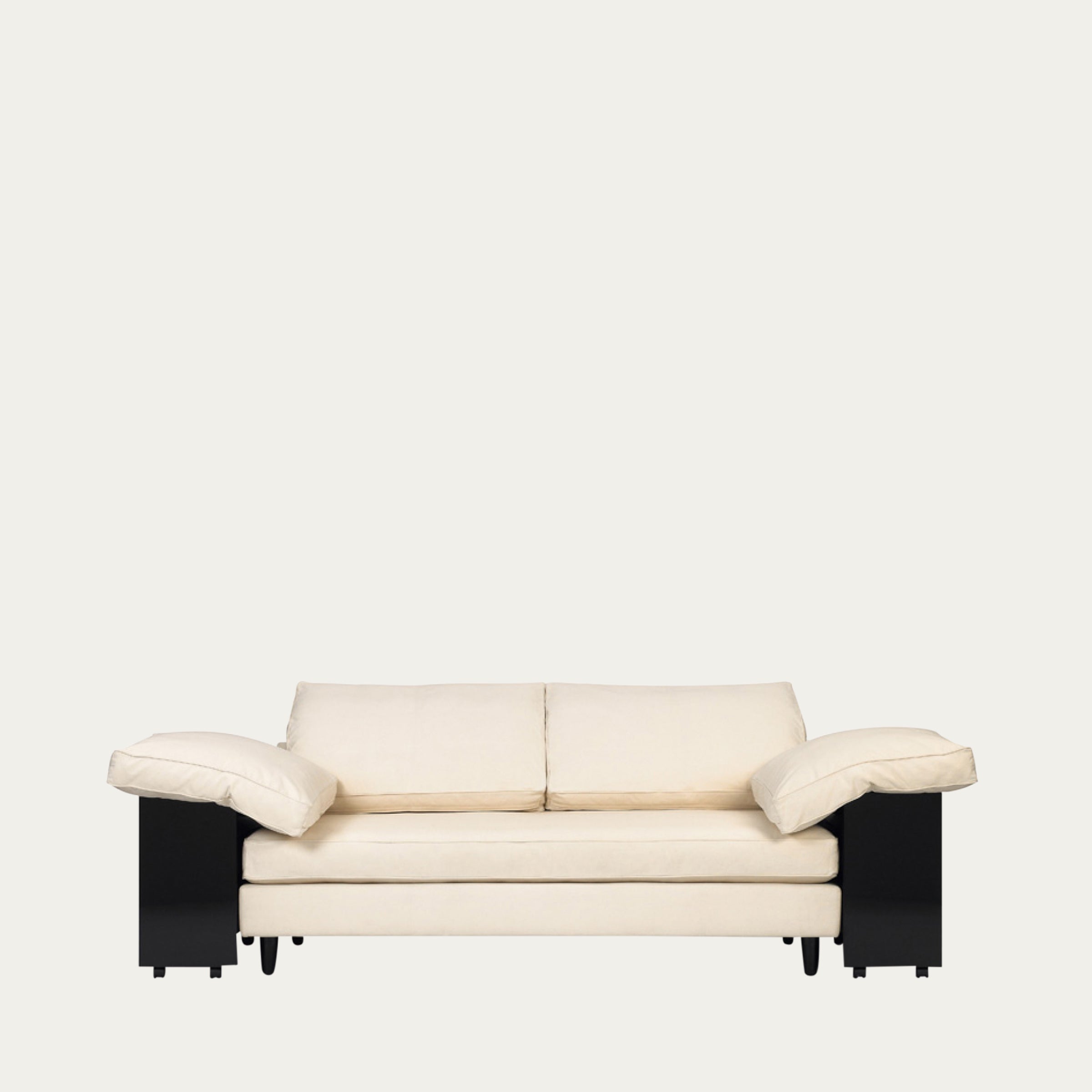 Frontansicht des Lota Sofas von Eileen Gray 1924 mit großzügigen Polstern, kontrastierendem schwarzem Unterbau und zeitloser Formsprache